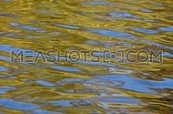 Colorful yellow and blue ripples and waves fast running on water surface, diagonal direction, moving flow background close up, Full HD 1080