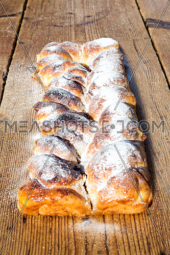 Strudel on a Wooden Table Resting All Sprinkeld With sugar Powder