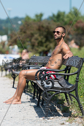 Smiling Athlete With Naked Torso Sitting And Resting On Bench