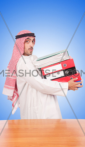 Arab businessman with many folders against gradient 