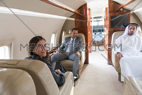 Young middle eastern successful businessmen enjoyed by talking with Arab business partner while sitting in private jet