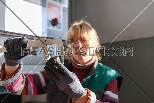 a woman working in a modern factory for the production and processing of metals, preparing and measures materials that go to the processing of CNC machines. High quality photo