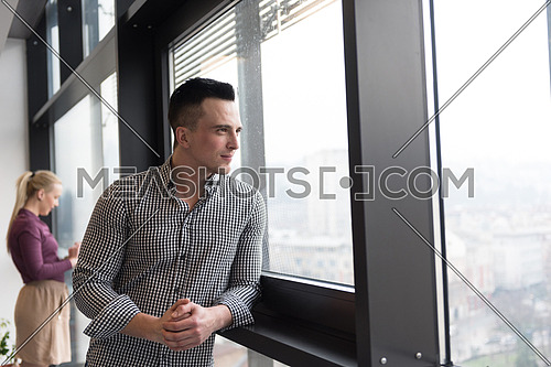 happy young business at modern office looking through window