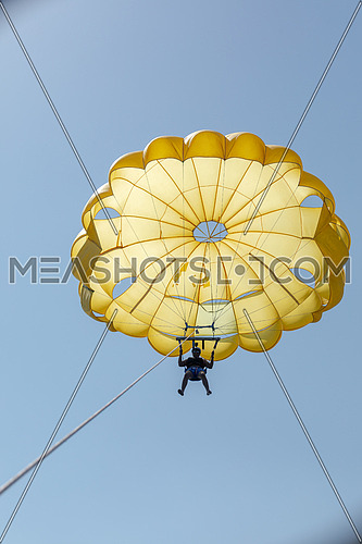 Tourist parasailng in the Red Sea by day