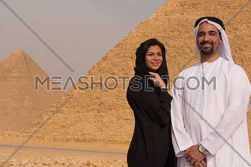 portrait of  Emiratie man and his wife as tourists at the pyramids