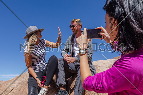 long shot for a group of tourist taking photos using mobile phone at Sinai Mountain for wadi Freij at day.