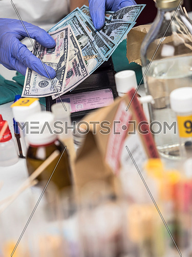 Police specialist examines wallet with money from a crime scene, conceptual image