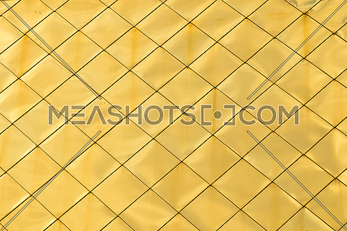Golden metal shiny vivid rooftop tile panels texture background with highlights and reflections