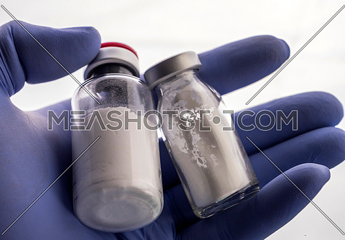 Detail of hand medical holding a vial, conceptual image