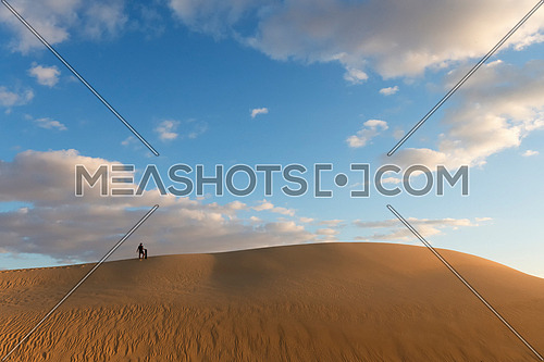  man with Sand board waking on top of high sand dunes desert in day light  with cloudy blue sky in Siwa Oasis, Egypt Adventure and Tourism wallpaper.