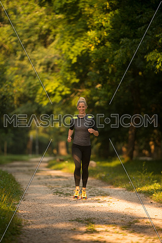 Young Woman Running In Wooded Forest Area - Training And Exercising For Trail Run Marathon Endurance - Fitness Healthy Lifestyle Concept