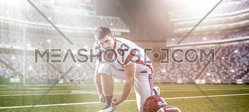 American Football Player preparing for match on big modern stadium field with lights and flares