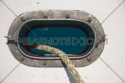 An opening in a ship shows the anchor rope