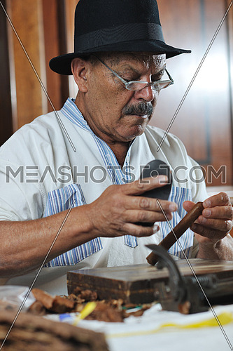 older senior man making luxury handmade cuban cigare