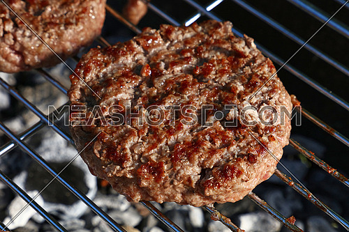 Close up beef or pork meat barbecue burgers for hamburger prepared grilled on bbq grill, high angle view