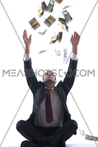 Portrait of a business man holding and catch falling money bills, isolated on white background in studio