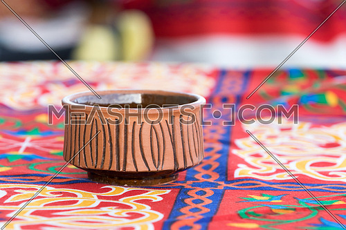 Potter over a table covered by oriental table clothe