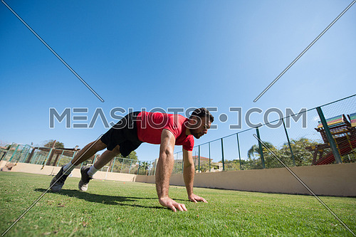 young middle eastern man athlete enjoys doing the extreme push-ups outside