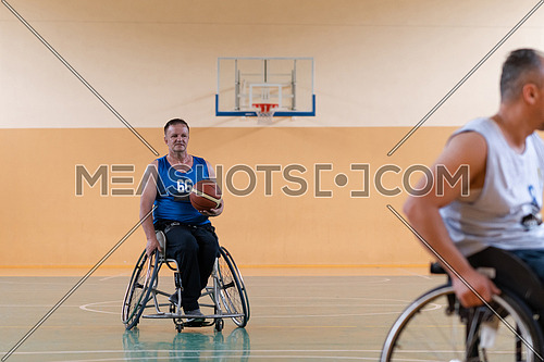 disabled war veterans in action while playing basketball on a basketball court with professional sports equipment for the disabled. High quality photo