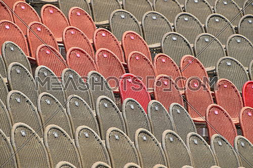Rows of empty grey and red seats in open air concert hall auditorium, low angle side view