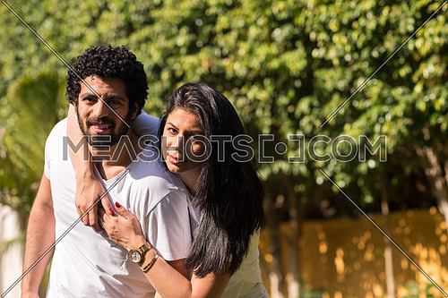 Young Middle Eastern couple enjoying the beautiful summer day in the garden with a smile and happiness