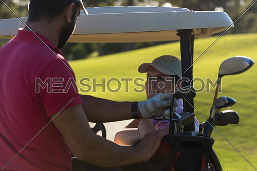 couple in buggy cart on golf course