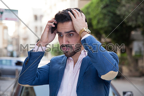 A young business man talking on the phone in the street