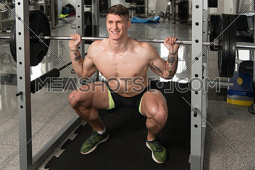Man Working Out Legs With Barbell In A Gym - Squat Exercise