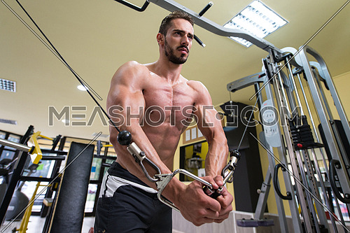 Young Man Bodybuilder Is Working On His Chest With Cable Crossover In A Gym