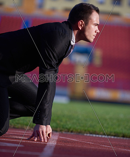 business man in start position ready to run and sprint on athletics racing track