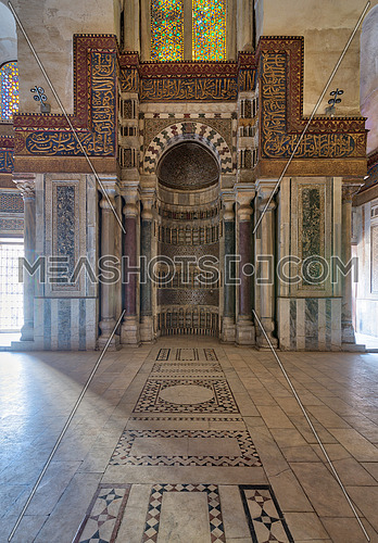 Mausoleum of Sultan Qalawun with decorated colorful marble niche (Mihrab) embedded in ornate marble wall, and colorful stain glass windows, Moez Street. Cairo, Egypt