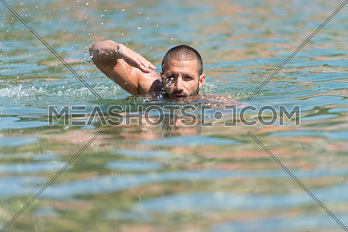 Young Man Swimming In Lake Green Water