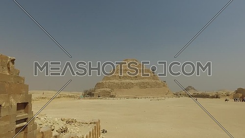 Pan Left form Saqqara Pyramid till an small temple ruins at day.