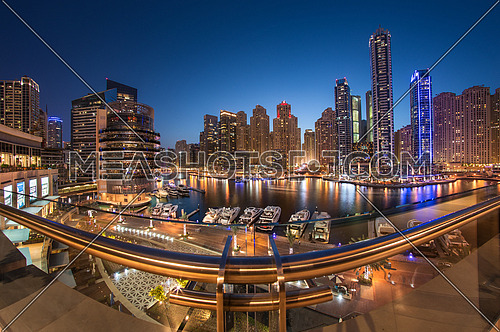Dubai Marina Towers in a beautiful blue sunset with reflection on dubai marina bay