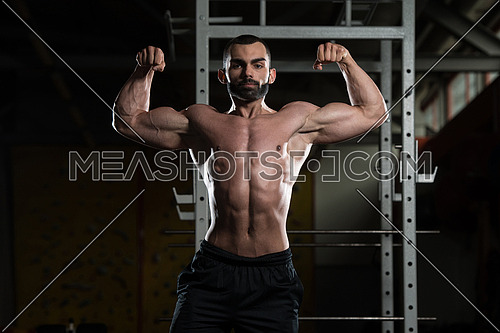 Portrait Of A Young Fit Man Performing Front Double Biceps Pose - Muscular Athletic Bodybuilder Fitness Model Posing After Exercises