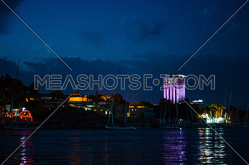 A view of Aswan city at night in front of the Nile river in Egypt