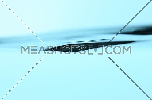 Shaking pure clear cold water surface level spinning and whirling in transparent glass jar or teapot, close up, low angle side view, slow motion