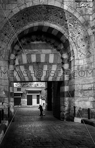 a man sweeping the street under the gate arch of El Moez ST cairo Egypt