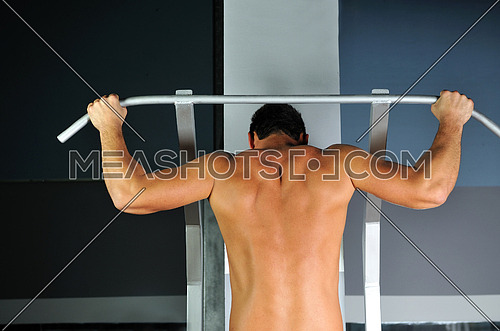 young man with strong arms working out in gym and representing their streinght and vitality