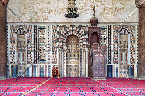 Colorful decorated marble wall with engraved Mihrab (niche) and wooden Minbar (Platform) at the Mosque of Al Nasir Mohammad Ibn Qalawun, situated in the Citadel of Cairo in Egypt