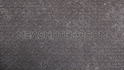 Background texture of gray industrial anti slip embossed metal steel plate surface with diagonal bumps of diamond pattern, close up
