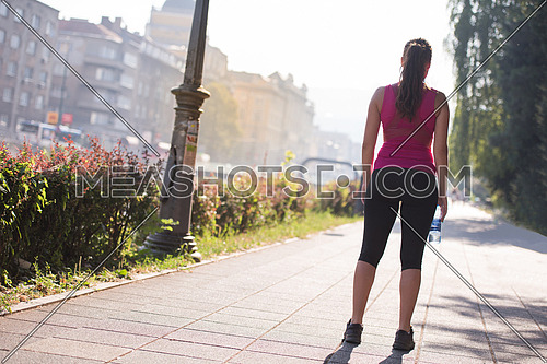 young sporty woman jogging at sunny morning in the city