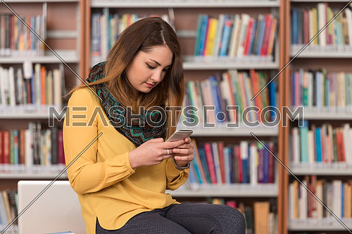 Female Student Talking On The Phone In Library - Shallow Depth Of Field