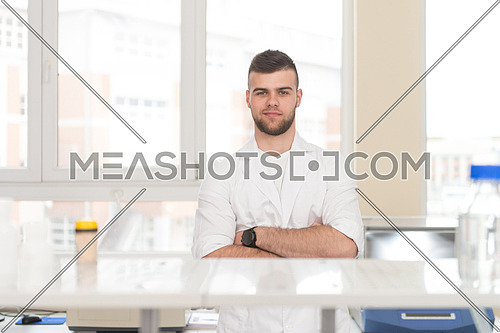 Portrait Of A Caucasian Student In A Chemistry Lab Smiling And Looking In The Camera With Hands Folded
