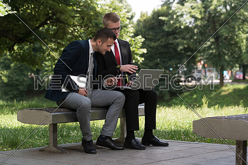 Happy Business Men Using Tablet Pc Outside On A Park Bench
