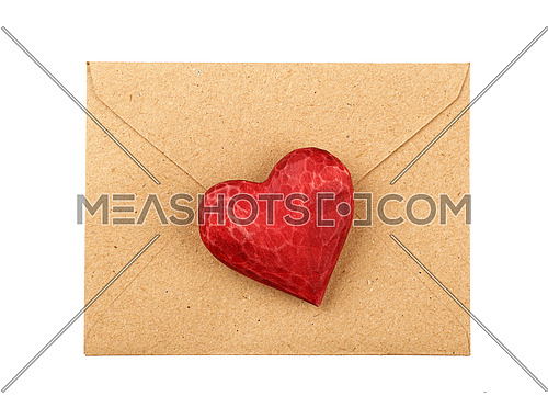 Close up one red painted natural wooden carved heart over brown paper envelope isolated on white background