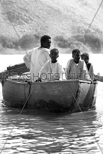 3 children and an adult in a rowing boat in the river NILE