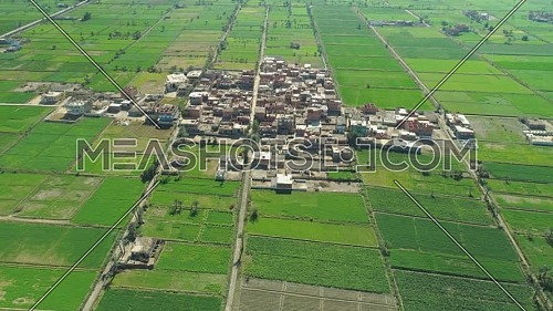 Aerial shot for village showing green fields and hosues at day
