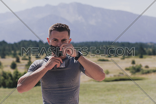 Young man and woman in protective masks running and doing exercises outdoors in the morning. Sport, Active life, Jogging during quarantine. Covid-19 new normal. High quality photo. Selective focus.