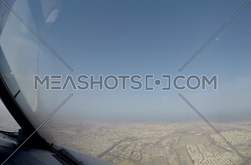 inside cockpit shot  flying over a city  at day